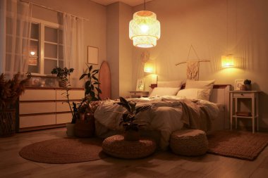 Yatak odasının içinde sörf tahtası, gece parlayan lambalar ve bitkiler var.