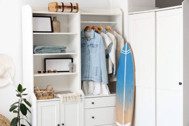 Sörf tahtası ve dolabı olan bir ışık odası.