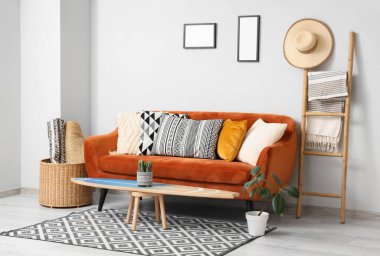 Oturma odasının içinde sörf tahtası, kırmızı kanepe ve merdiven var.