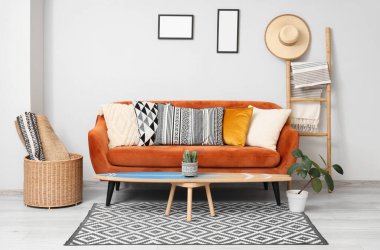 Oturma odasının içinde sörf tahtası, kırmızı kanepe ve merdiven var.