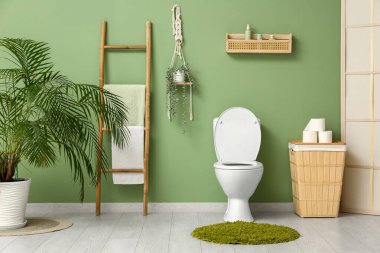 Seramik klozet, kağıt rulo ve sepetli şık tuvaletler.