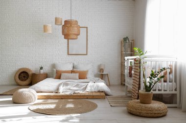 İçinde yatak, bebek beşiği ve bitkiler olan ışık odası.