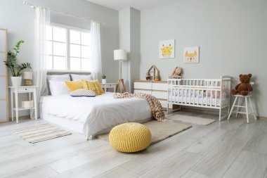 Yatak, bebek beşiği ve oyuncakları olan ışık odasının içinde.