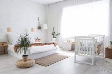 İçinde yatak, bebek karyolası ve lambalar olan bir oda.