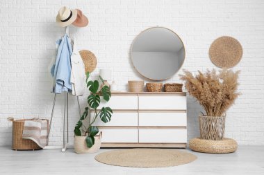 Hasır sepetli, elbise askılı ve aynalı koridorun içi.