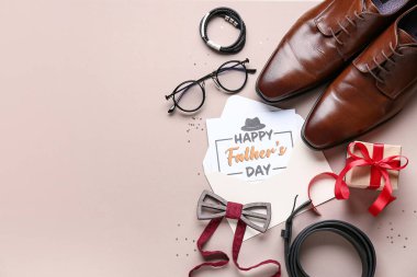 Bej arkaplanda Babalar Günü için hediye kutusu, ayakkabı ve aksesuarlar olan bir kartpostal.