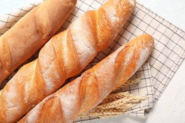 Açık mavi arkaplanda taze baget ve buğday, yakın plan.