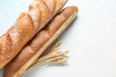 Açık mavi arkaplanda taze baget ve buğday, yakın plan.