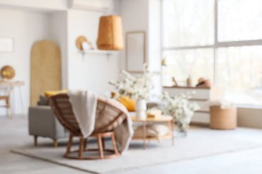 Koltuğu, koltuğu ve çiçekli dalları olan bulanık oturma odası manzarası