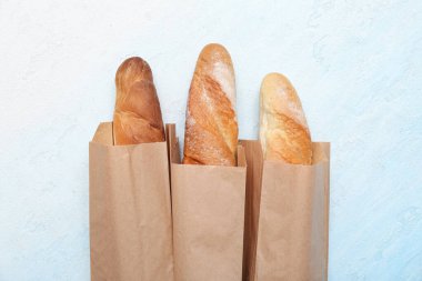 Açık mavi arka planda taze baget torbaları.