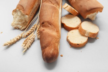 Gri arkaplanda taze baget ve buğday, yakın plan.