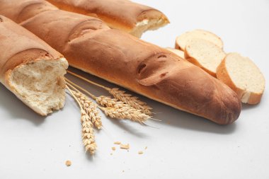 Gri arkaplanda taze baget ve buğday, yakın plan.