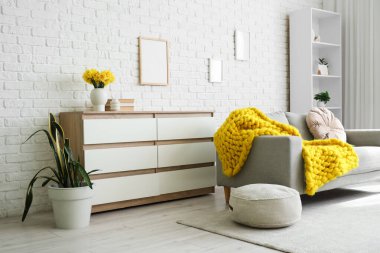 İçinde kanepe, tuvalet ve vazo olan oturma odası.