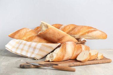 Ahşap tahta ve hasır kâse. Gri arka planda taze baget var.