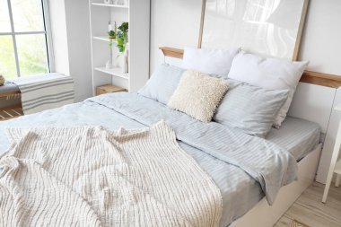 Konforlu yatak odası, battaniye ve çiçekli.