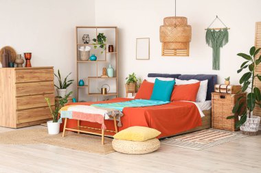 Şık bir yatak odası, rahat bir yatak, ev bitkileri ve ahşap mobilyalar.