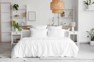 Yatak odasının içi, rahat yatak odası, çiçekler ve komodinlerle dolu.