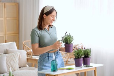 Evde lavanta yaprakları kesen genç bir kadın.