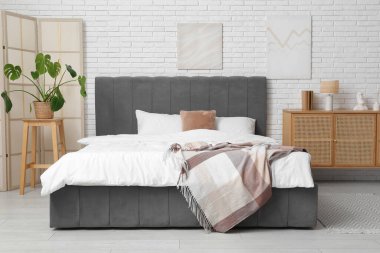 Katlanmış ekran ve palmiye bitkisi olan yatak odasının içi