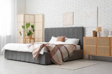 Katlanmış ekran ve palmiye bitkisi olan yatak odasının içi