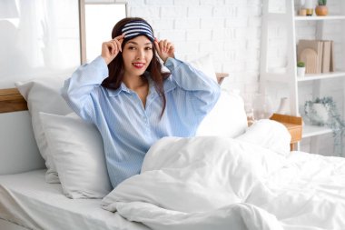 Uyku maskesi takmış güzel genç bir kadın evde yatıyordu.