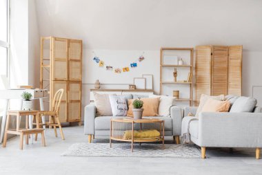 Gri kanepe ve sehpanın üzerinde lavanta çiçekleri olan şık bir oturma odası.