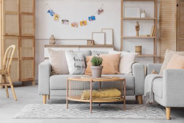 Gri kanepe ve sehpanın üzerinde lavanta çiçekleri olan şık bir oturma odası.