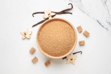 Beyaz arka planda bir kase tatlı vanilya şekeri.