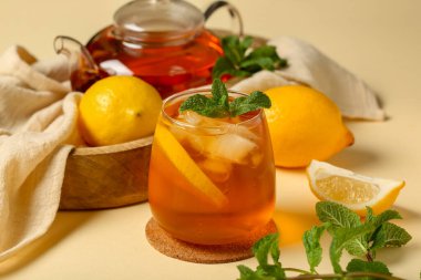 Çaydanlık ve bir bardak limonlu buzlu çay. Arka planda nane şekeri, yakın plan.