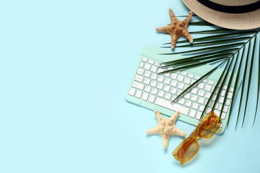 Mavi arka planda palmiye yaprağı, güneş gözlüğü ve yıldız yıldızları olan bilgisayar klavyesi
