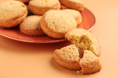 Kahverengi arka planda tatlı kurabiyeli tabak, yakın plan.