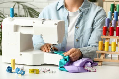Atölyede elbise diken kadın terzi, yakın plan.