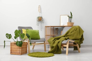 Oturma odasının içinde sandalyeler, masa ve sepetlerde bitkiler var.