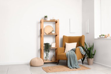 Oturma odasının içinde koltuk, raf ve bitkiler var.