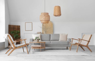 Rahat gri kanepesi, sehpası ve koltukları olan şık bir oturma odası.