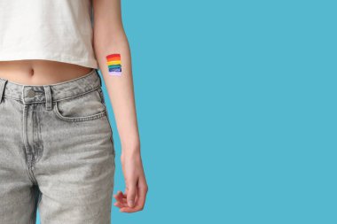 Mavi arkaplanda çizilmiş LGBT bayrağı olan kadın