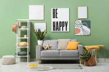 Gri kanepeli, çiçekli ve yaz dekorlu şık bir oturma odası.