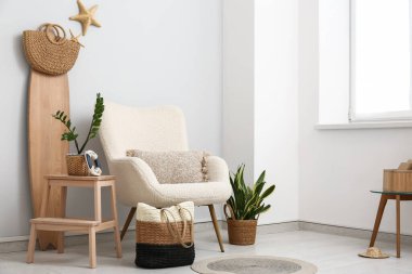 Beyaz koltuklu, el çantalı ve sörf tahtalı şık bir oturma odası.