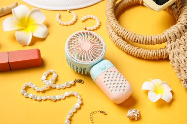 Yaz aksesuarları ve sarı arka planda mini yelpaze.