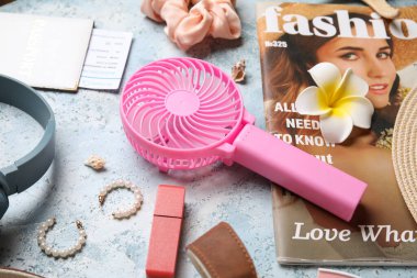 Kadın aksesuarlı moda dergisi ve mavi grunge arka planda mini fan.