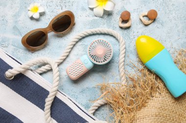 Kadın aksesuarlı çanta ve mavi grunge arka planda mini fan.