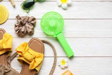 Beyaz ahşap arka planda kadın aksesuarlar ve mini yelpaze.