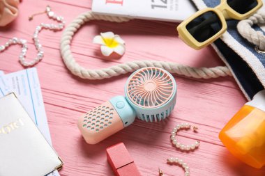 Yaz aksesuarları ve pembe ahşap arka planda mini yelpaze.