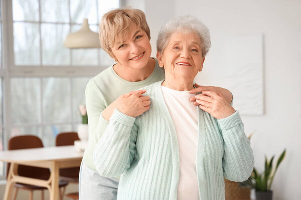 Mature woman hugging her mother at home