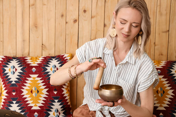 Женщина медитирует с Тибетской чашей для пения дома