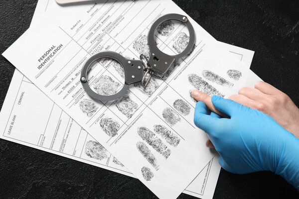 Criminalist taking fingerprints of suspect in police department