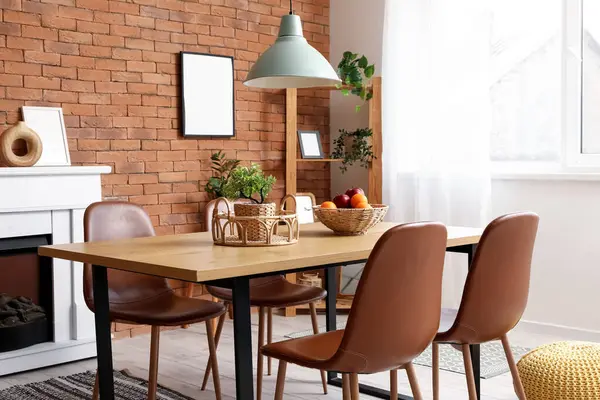 Yemek odasının içinde masa, şömine ve raf ünitesi var.