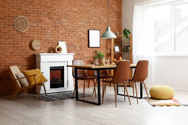 Masası, şöminesi ve koltuğu olan bir yemek odası.