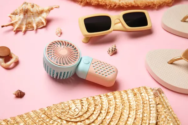 Kadın yaz aksesuarları ve pembe arka planda mini fan.