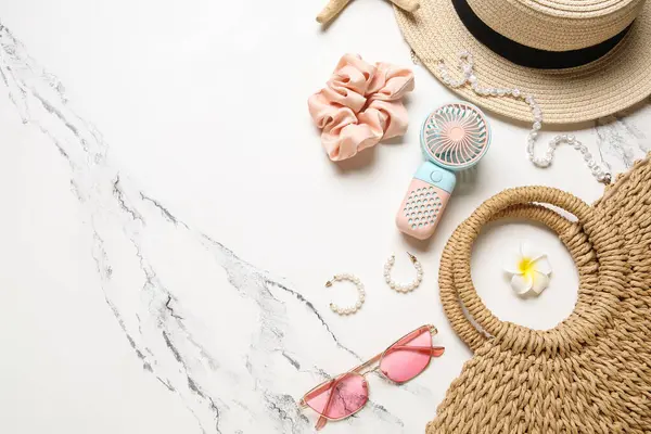 Kadın yaz aksesuarları ve hafif arka planda küçük yelpaze dolu çantalar.
